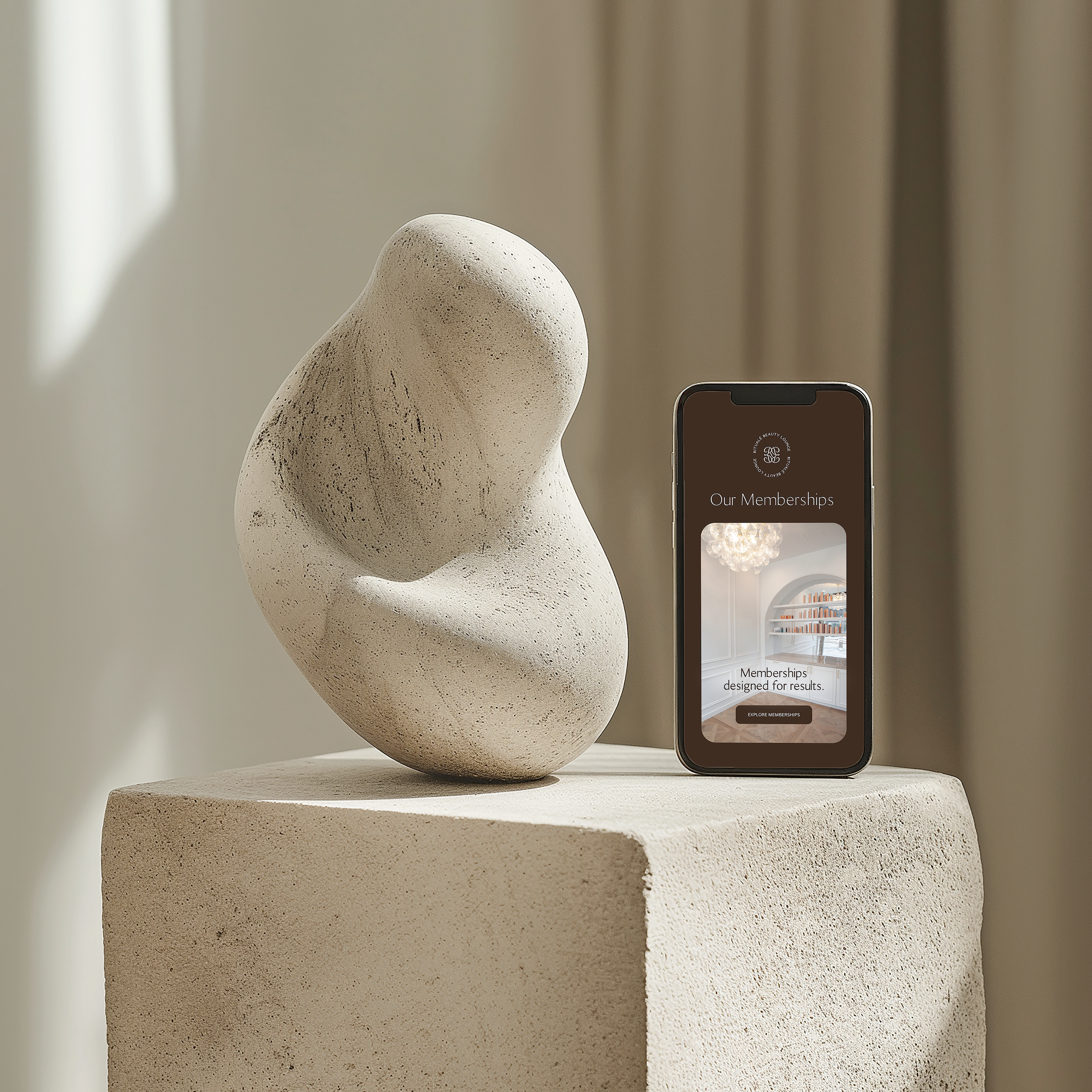 Stone sculpture on a pedestal with a smartphone displaying an app interface against a neutral background